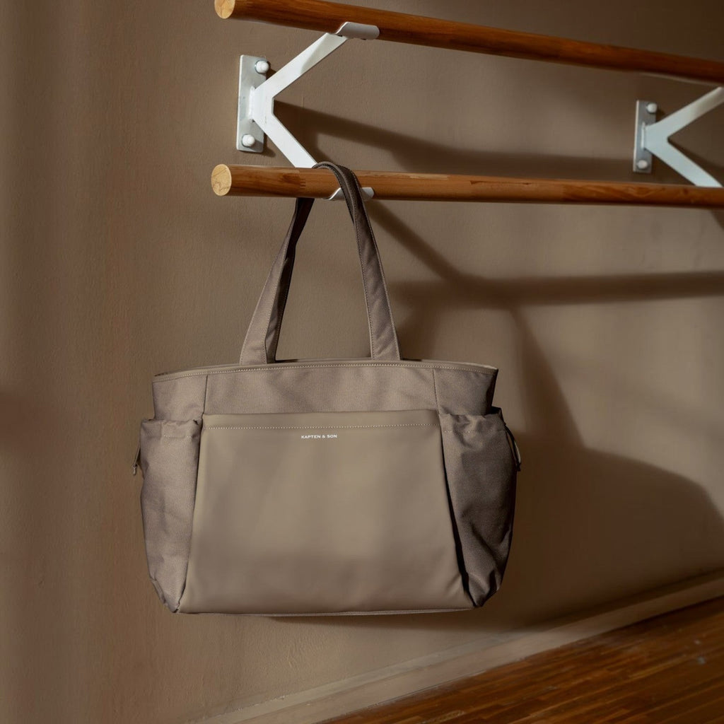 Lieblingstasche Hellvi Pro Large tote bag in taupe with side pockets hanging on a wooden rack