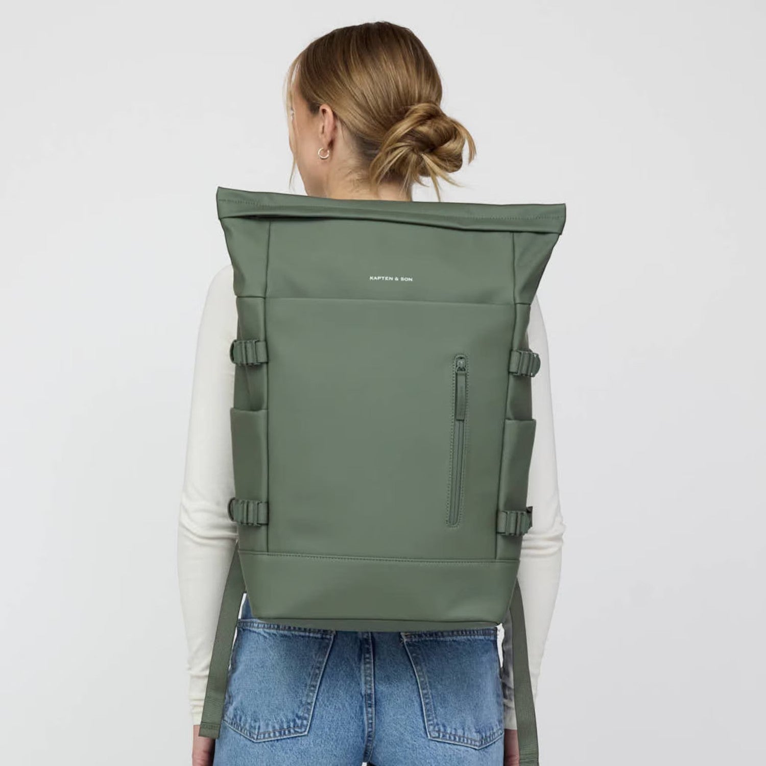 Lieblingstasche Helsinki Pro rolltop backpack in olive green worn by a woman against a plain background
