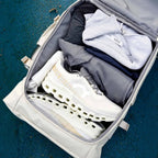 Lieblingstasche Helsinki Pro travel bag packed with white On Running sneakers and grey athletic apparel