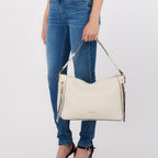 Lieblingstasche Hobo M shoulder bag in cream white with braided handle and gold zipper details held by a woman