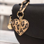 Lieblingstasche heart charm with leopard print pattern attached to a black textured handbag