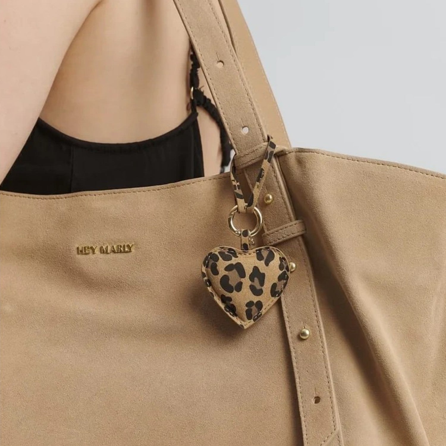 Lieblingstasche heart charm in leopard print leather hanging from a beige suede tote bag