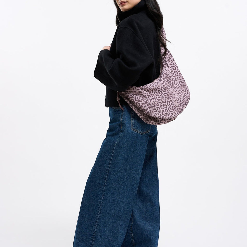 Lieblingstasche Moon Bag Ruffle in large size with a pink and black leopard print pattern worn over the shoulder.