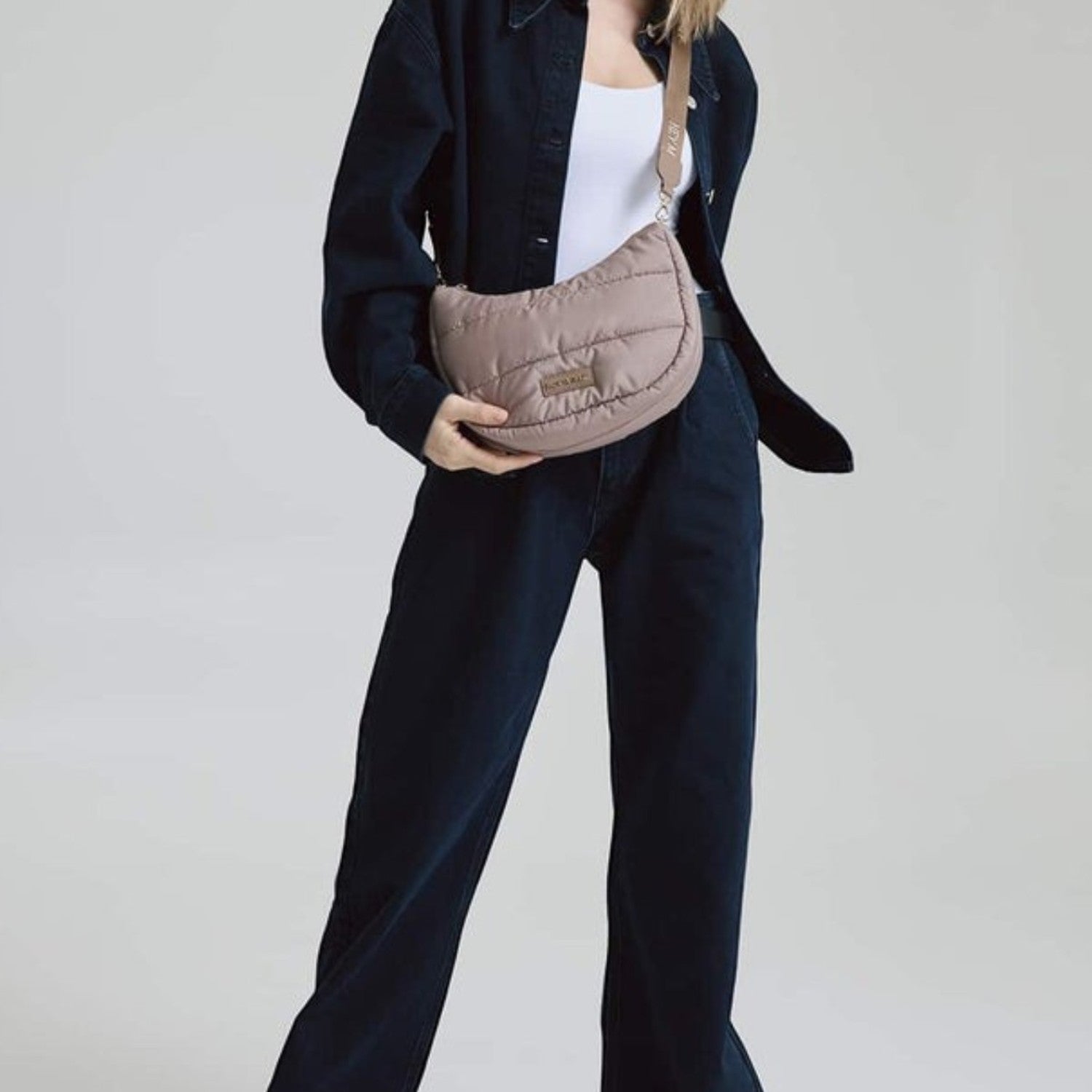 Lieblingstasche Lifetime Buddy S quilted taupe crossbody bag worn by a model in dark denim outfit