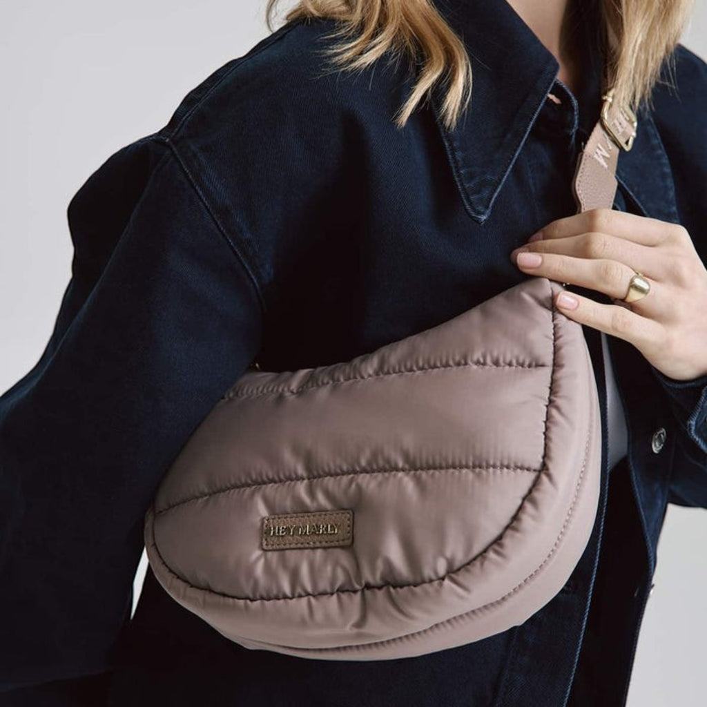 Lieblingstasche Lifetime Buddy S quilted taupe crescent crossbody bag worn by a woman in a dark denim jacket