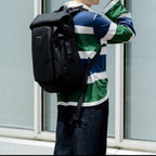 Lieblingstasche Lisbon Pro black travel backpack worn by a woman in a striped shirt outdoors