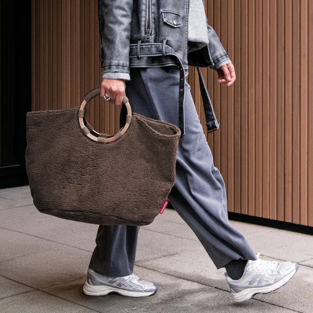 Lieblingstasche Loopbag Hobo in brown teddy fleece with round wooden handles carried by a person in casual attire