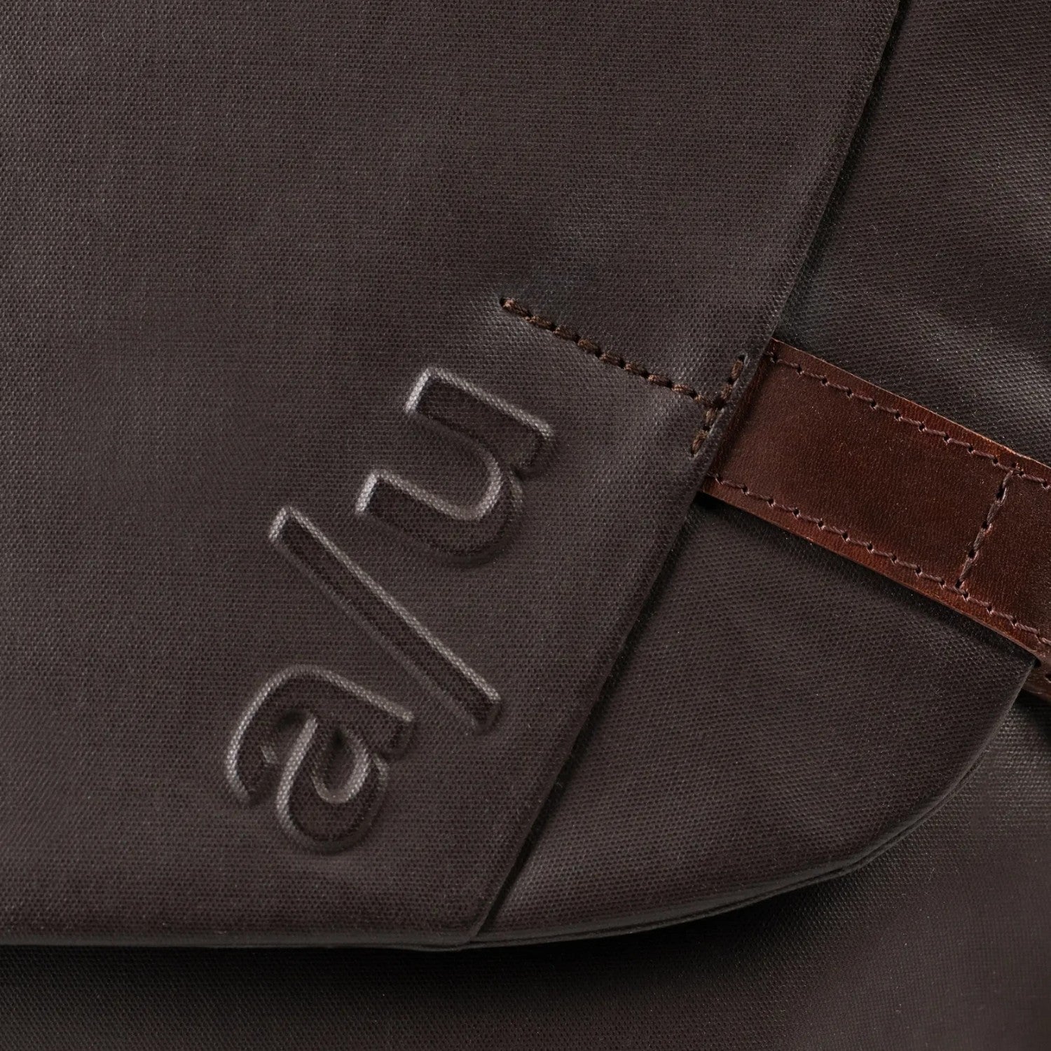 Close-up of the Lieblingstasche Matsumoto bag in dark brown fabric with embossed a/u logo and brown leather detail