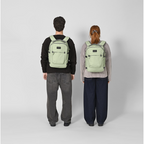 Two people wearing light green Lieblingstasche Midi20 city backpacks with minimalist design and padded straps.