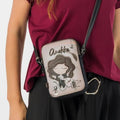 Lieblingstasche mini cross-body bag featuring a whimsical Anekke illustration in beige and black on a woman