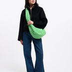Model wearing a Lieblingstasche Moon Bag Ruffle Large in neon green leopard print with a wide shoulder strap