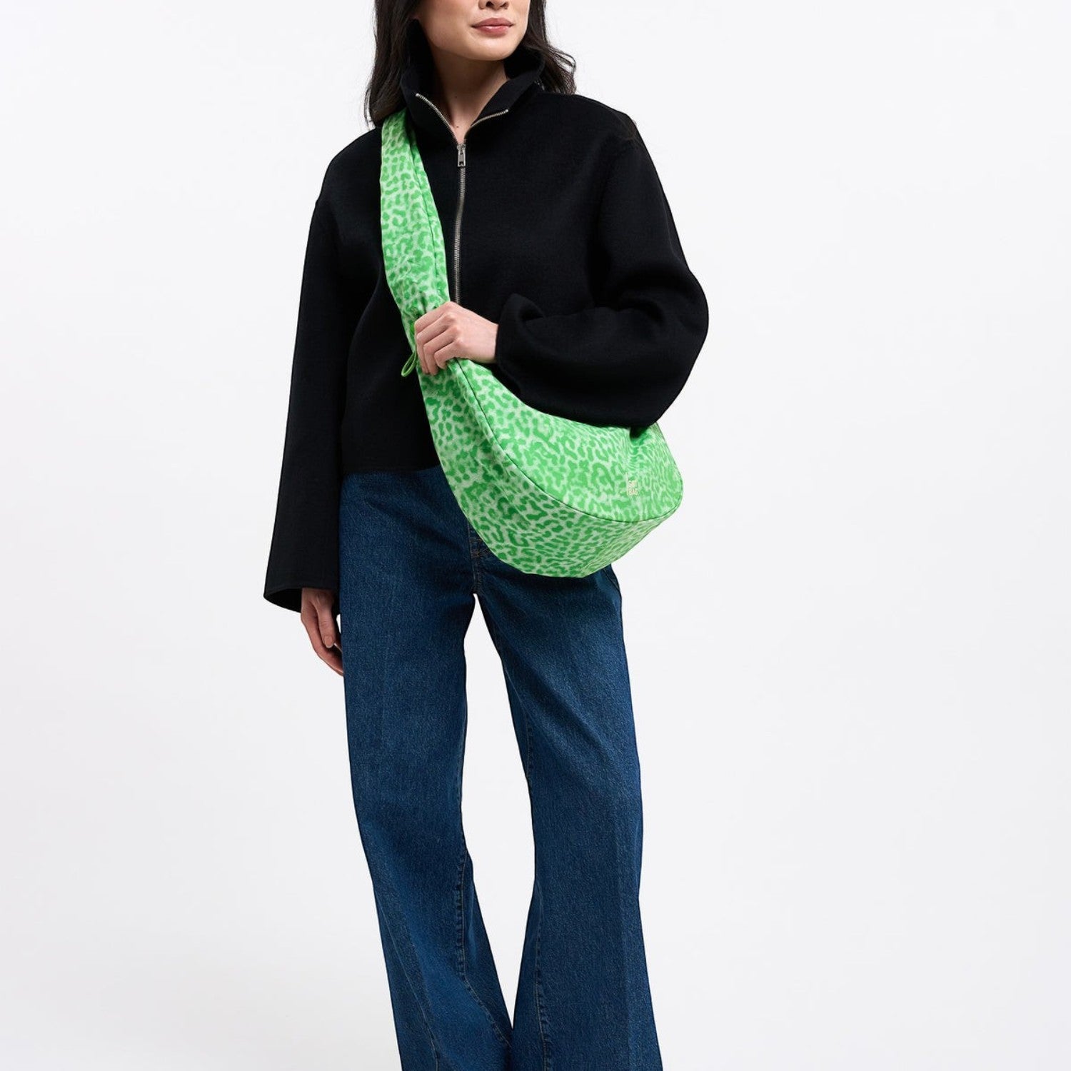 Model wearing a Lieblingstasche Moon Bag Ruffle Large in neon green leopard print with a wide shoulder strap
