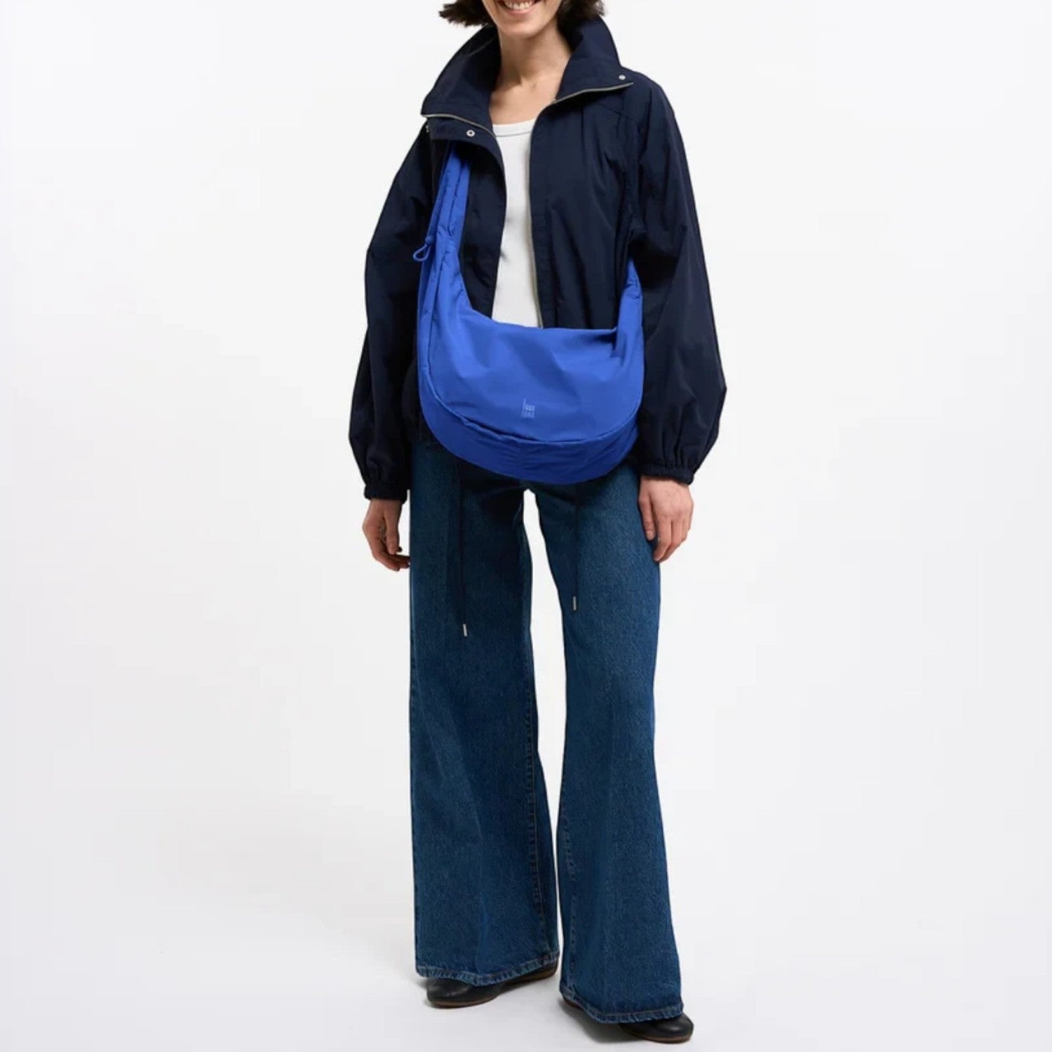 Lieblingstasche Moon Bag Ruffle Large in blue, worn as a crossbody bag by a woman in a dark jacket and jeans.