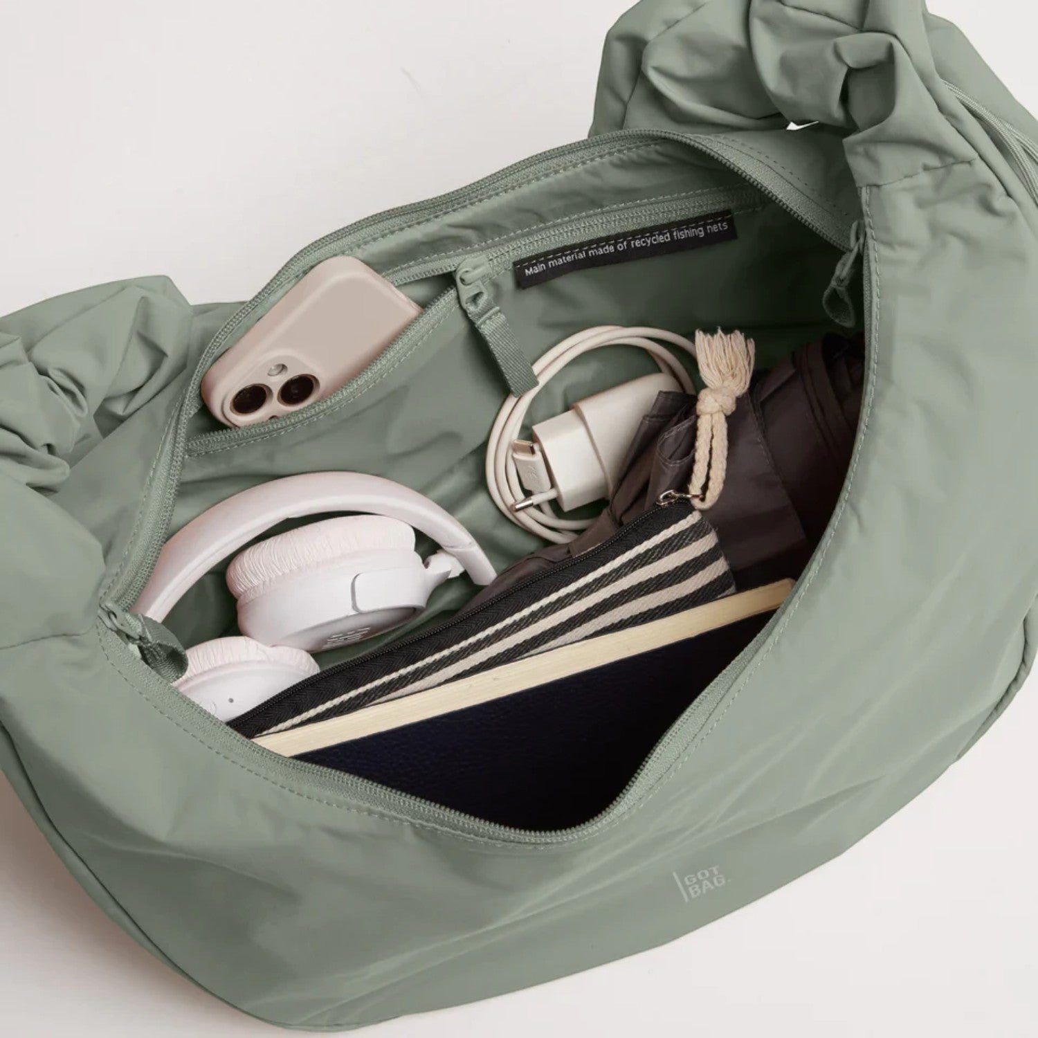 Lieblingstasche Moon Bag Ruffle Large in sage green, showing the spacious interior filled with daily essentials.