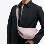 Lieblingstasche Moon Bag Small in dusty pink worn as a crossbody bag by a man in a black shirt