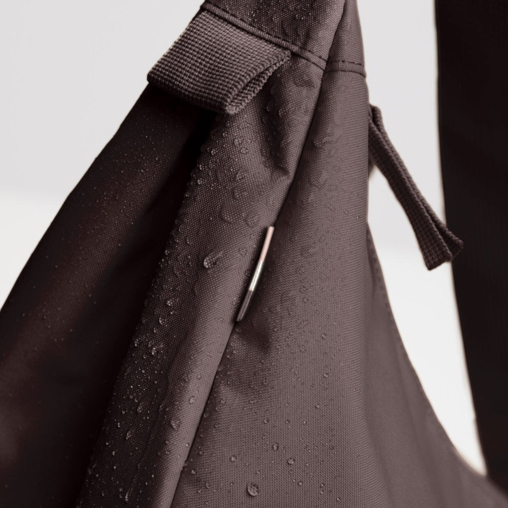 Lieblingstasche Moon Bag Large in dark brown water-resistant fabric with visible water droplets on the surface