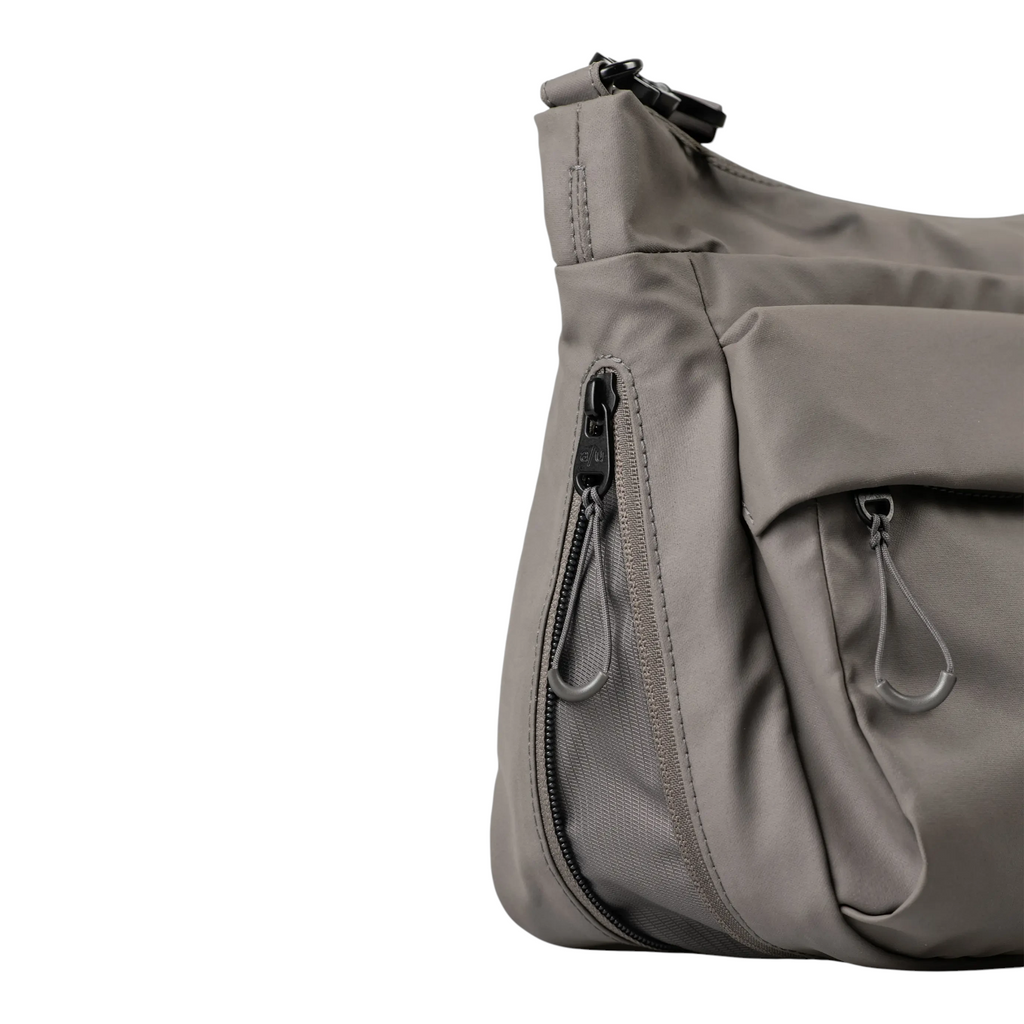 Lieblingstasche Nanuki RE lite grey crossbody bag featuring durable fabric, side zipper pocket, and cord pull tabs.
