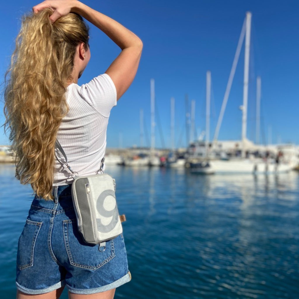 Lieblingstasche Nautik belt bag made from recycled sailcloth with number 9, worn as a crossbody bag at a marina.