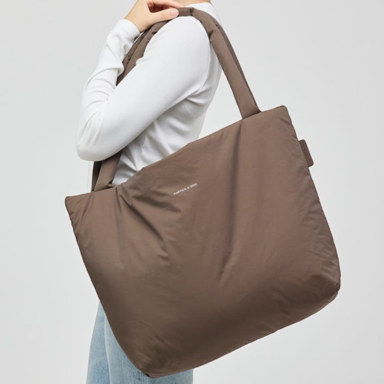Lieblingstasche Norva 2in1 brown shopper bag worn over the shoulder by a woman in a white long-sleeve top