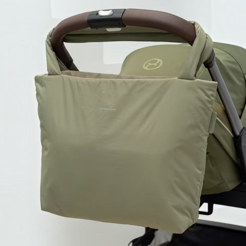 Lieblingstasche Norva 2in1 reversible shopper bag in sage green attached to a stroller handle