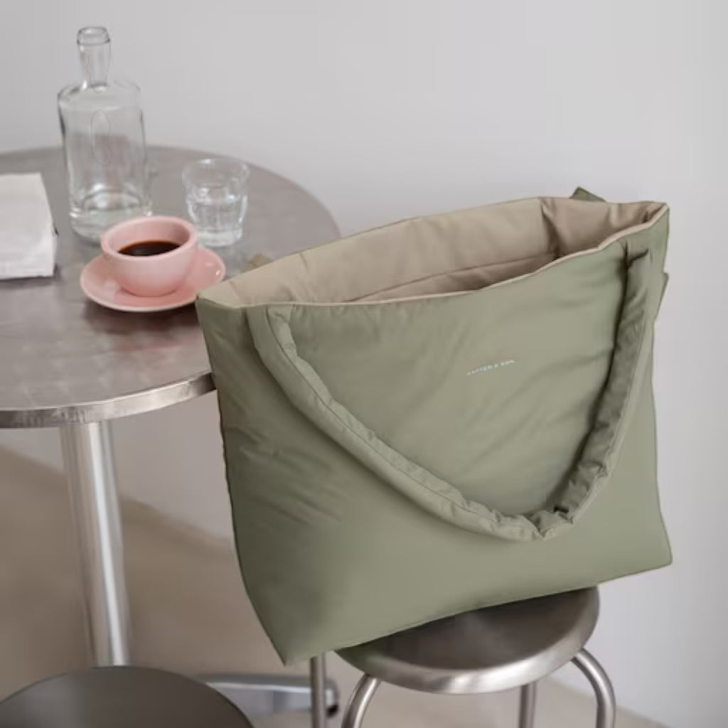 Lieblingstasche Norva 2in1 reversible shopper bag in sage green with padded handles on a stool