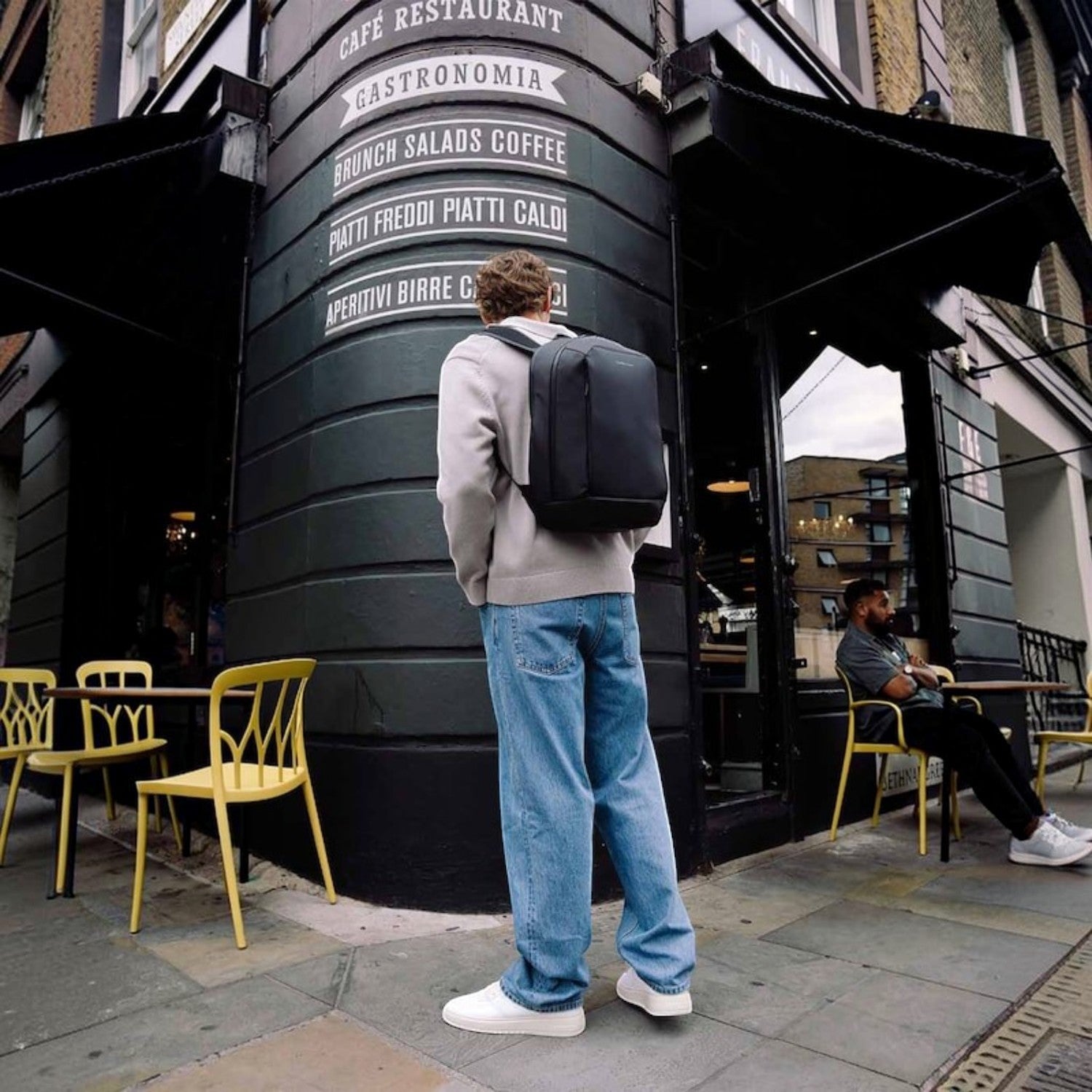 Lieblingstasche Oslo compact black wax pull-up leather backpack worn by a man on a city street