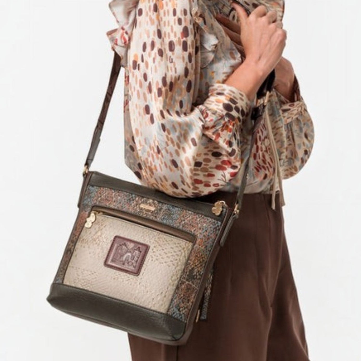 Woman wearing a Lieblingstasche multi-textured cross-body bag with brown and patterned panels