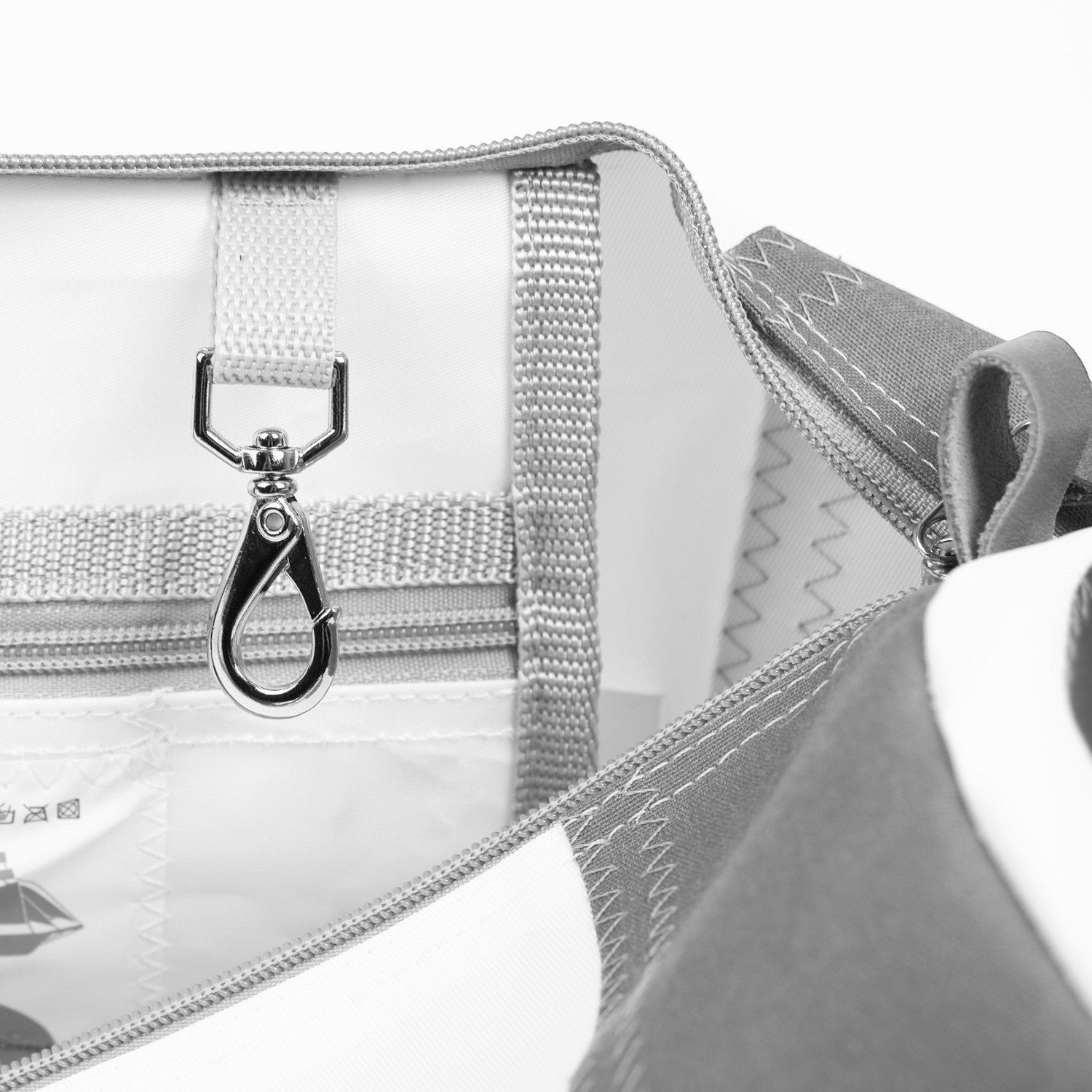 Interior detail of a Lieblingstasche Pirat bag featuring a white sailcloth lining, grey trim, and a metal key clip.