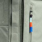 Close-up of the Lieblingstasche Pro Pack in sage green with a water-resistant finish and colorful zipper pull detail.