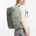 Lieblingstasche Pro Pack sage green laptop backpack worn by a woman, featuring ergonomic straps and side pockets.