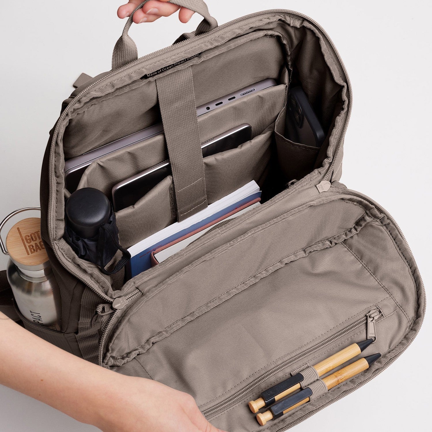Lieblingstasche Pro Pack backpack interior with laptop, tablet, phone, books, water bottle, and pens. Taupe fabric.
