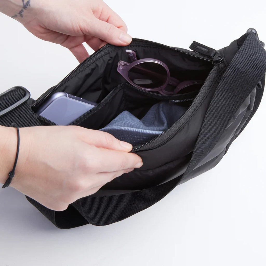 Lieblingstasche Puffer Moon Bag Small in black with interior compartments showing organized personal items