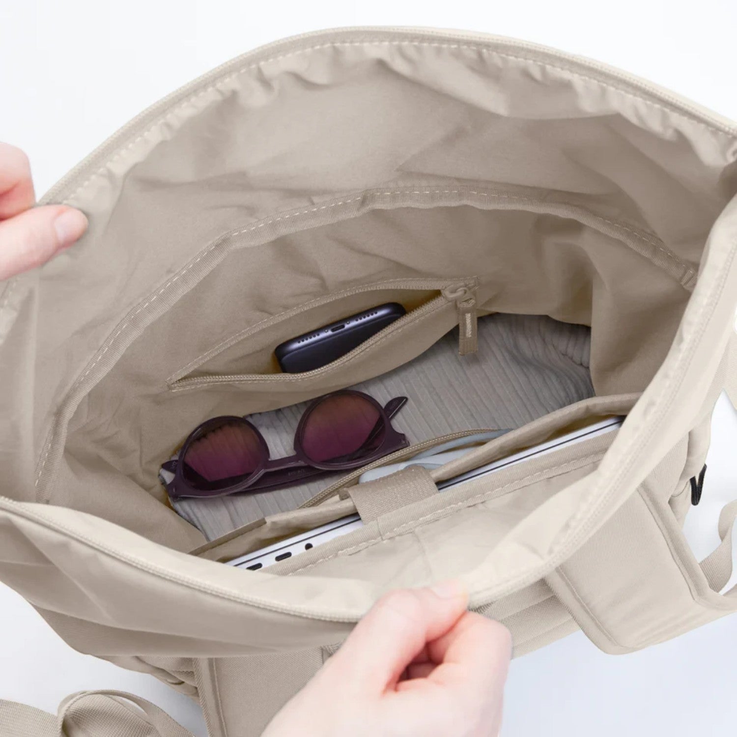 Lieblingstasche Rolltop Easy backpack interior view showing beige fabric, laptop compartment, and zippered pocket.