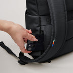 Lieblingstasche Rolltop Easy Small black backpack showing a hand placing a smartphone into the hidden back pocket.