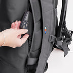 Lieblingstasche Rolltop Lite 2.0 backpack in grey showing a hand placing a smartphone into the side zipper pocket