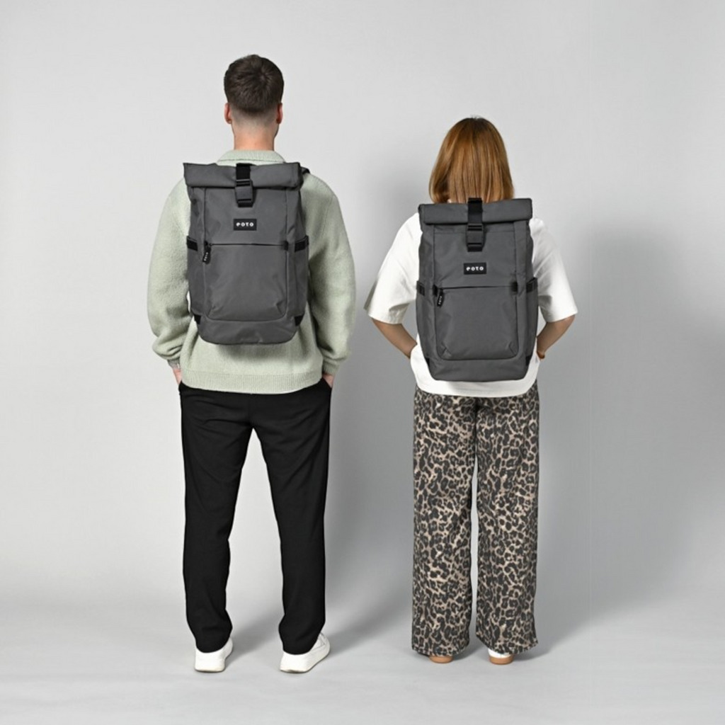 Lieblingstasche Rolly32 grey rolltop backpack worn by a man and woman, showing the back view and adjustable straps.