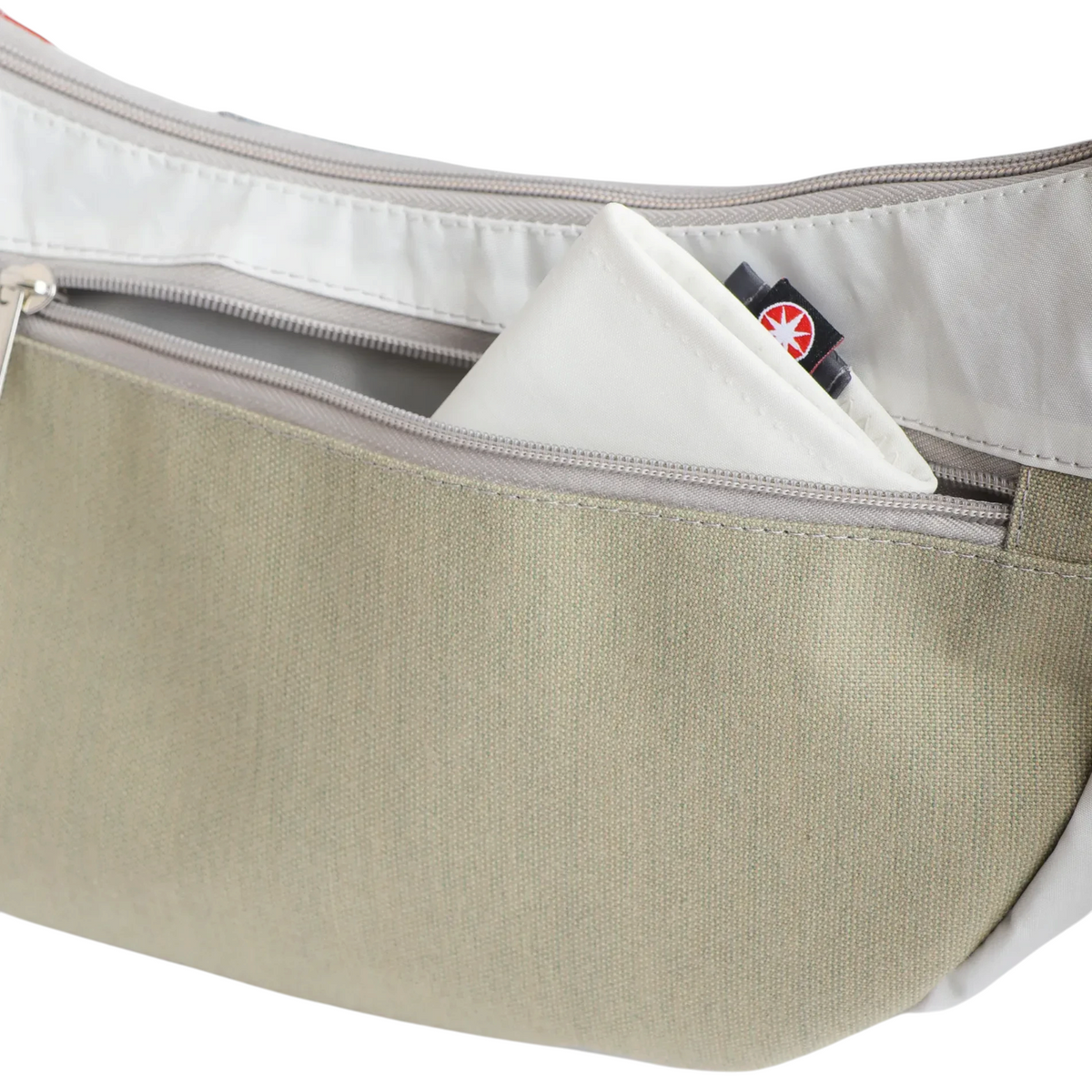 Lieblingstasche Roop L bag featuring a beige canvas exterior, white trim, and a zippered pocket with a small tag.