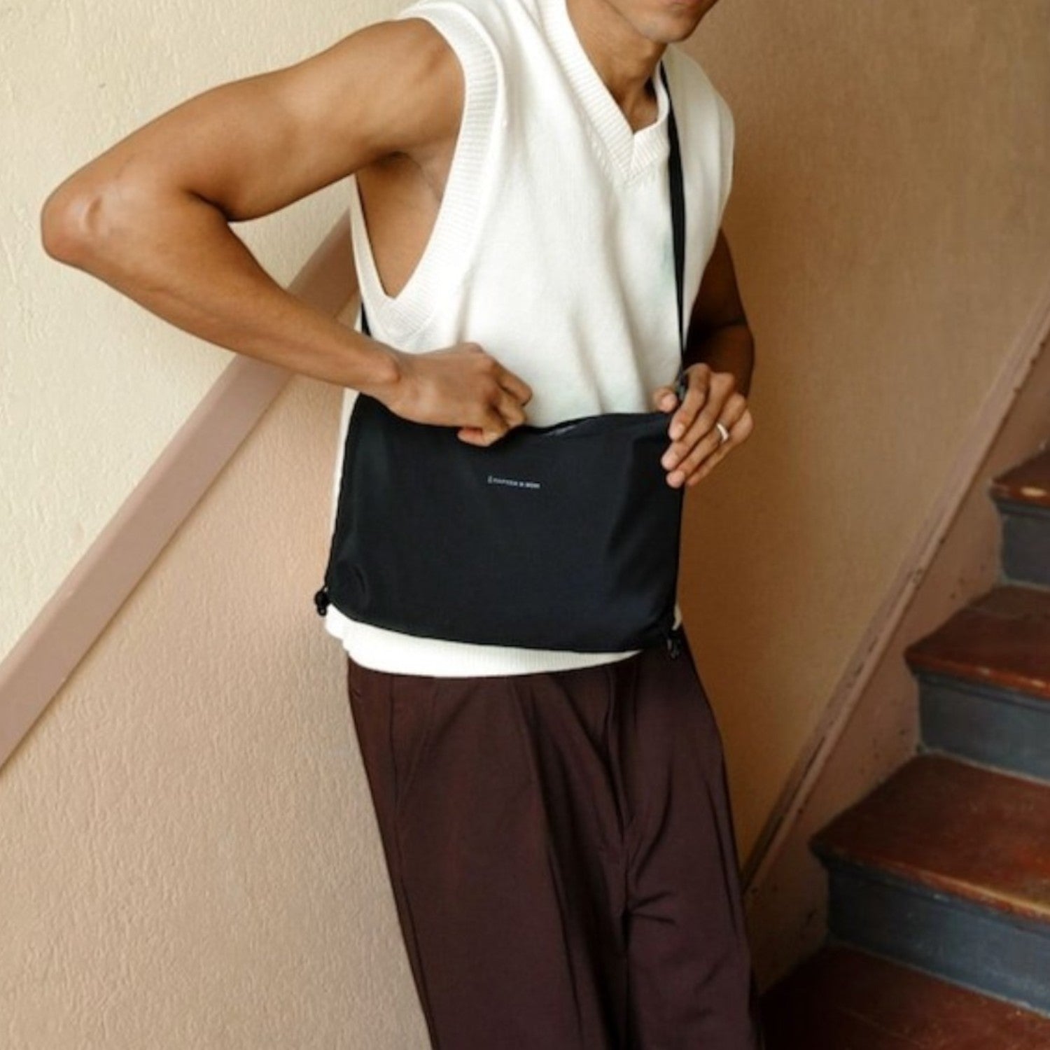 A man wearing a black Kapten & Son Skara Small crossbody bag from Lieblingstasche, styled with a white vest.