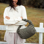 Lieblingstasche Skara Small Quilted olive green shoulder bag with a ruched handle worn by a smiling woman outdoors