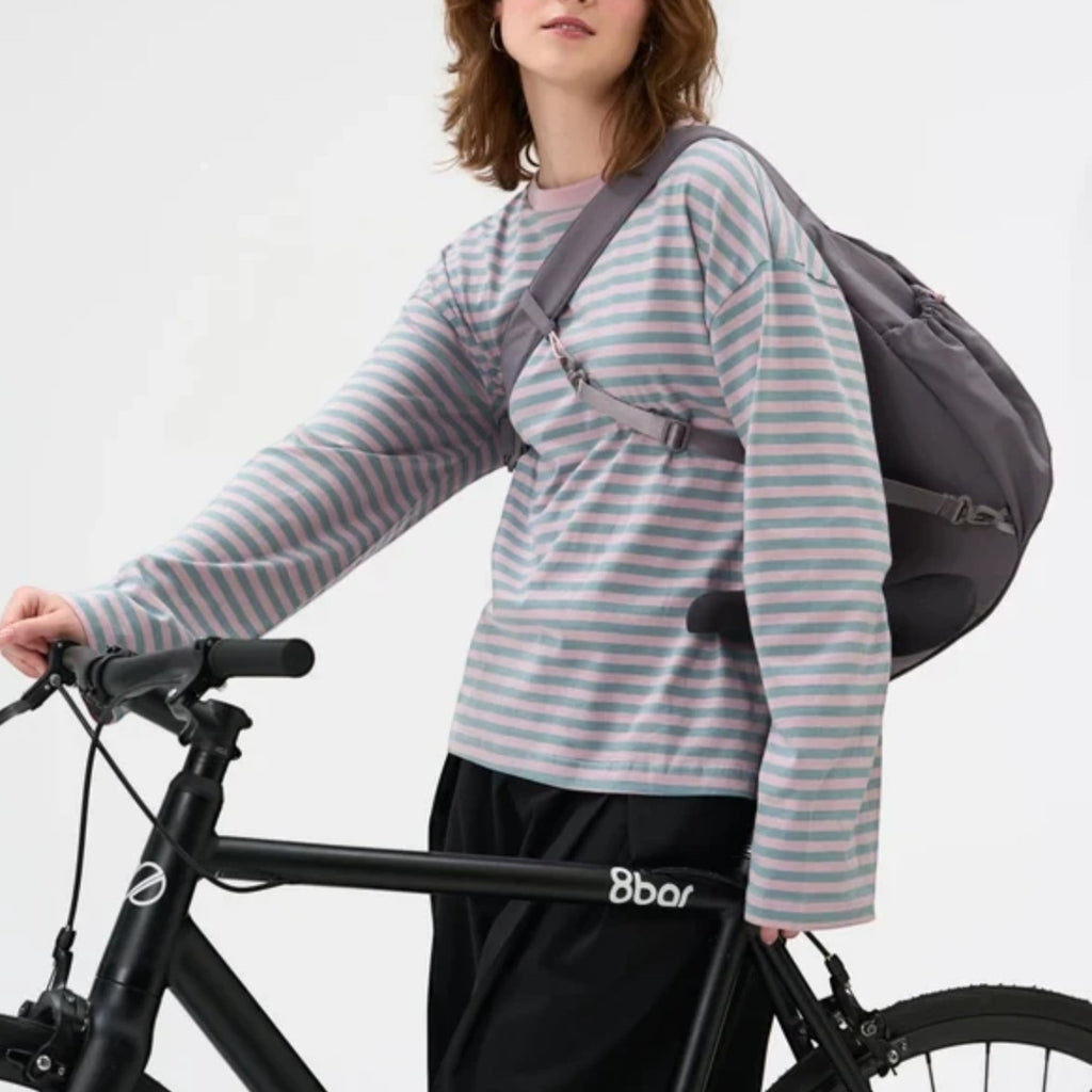 Lieblingstasche Slouchy Bag in grey worn as a crossbody bag by a woman on a bicycle