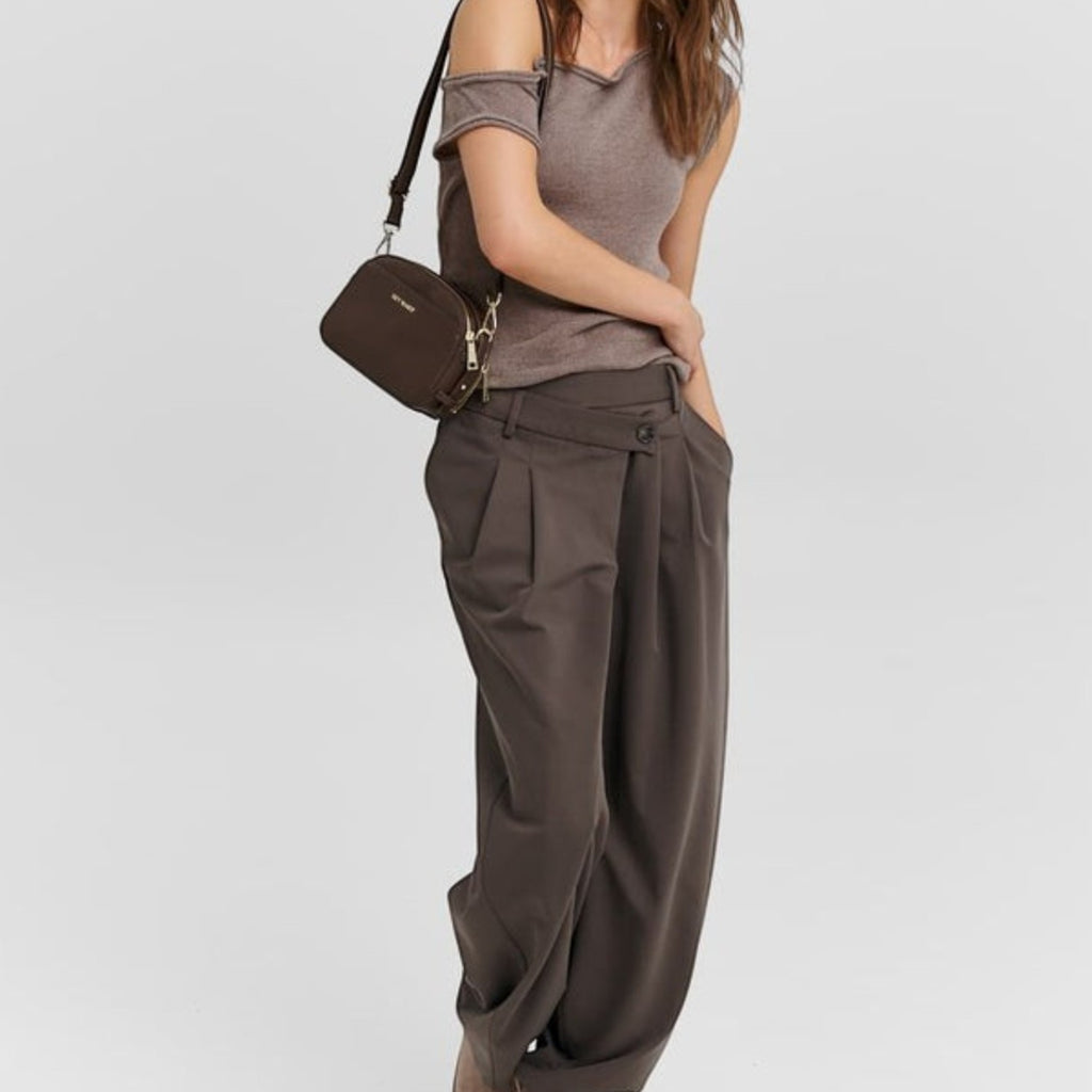 Model wearing a Lieblingstasche Style Mate dark brown crossbody bag with a casual brown top and wide-leg trousers