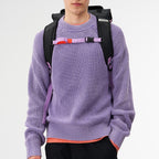 Lieblingstasche Trip Pack black backpack with purple straps worn by a man in a lavender sweater