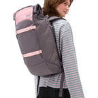 Lieblingstasche Trip Pack rolltop backpack in grey and pink with adjustable straps worn by a woman