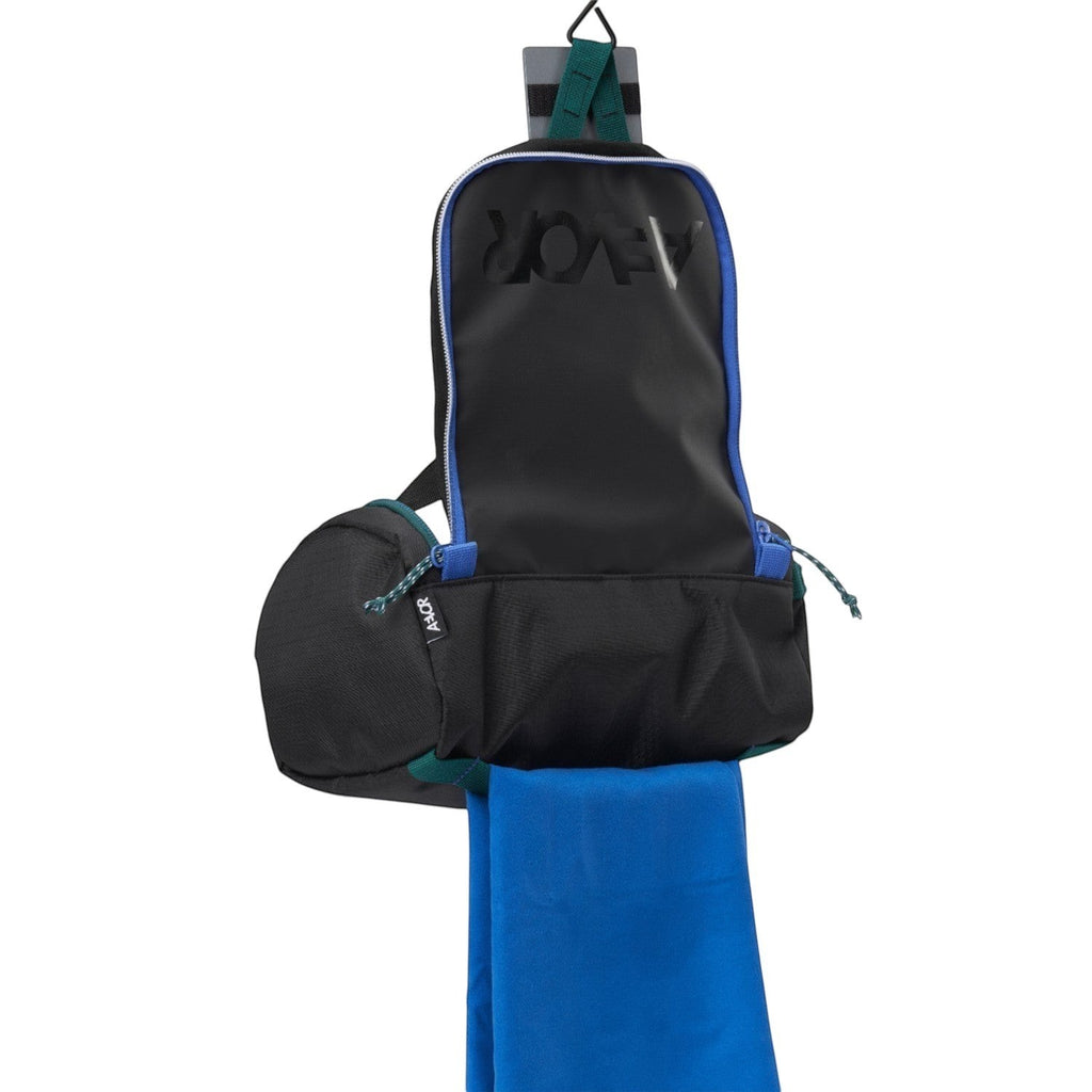 Lieblingstasche Wash Pack in black with blue accents, featuring a hanging design and a bright blue towel attached.